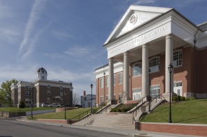 A significant fascia/frieze and vertical masonry pilasters relate to similar features of the historic courthouse.
